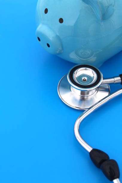 istock a stethoscope and a piggy bank lie on a blue background. 1387317824