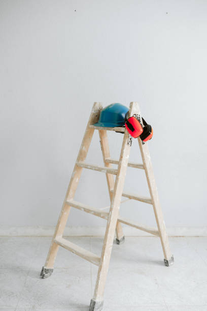 istock ladder, blue protective helmet and ear defenders at construction site. Home improvement, renovation 1387317846