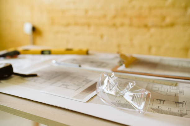 istock blueprints, ear defenders, protection glasses and tools on architect workspace at construction site 1387317875