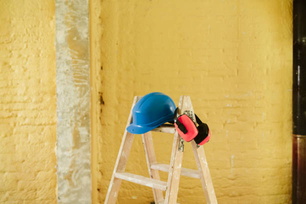 istock ladder, blue protective helmet and ear defenders at construction site. Home improvement, renovation 1387317877
