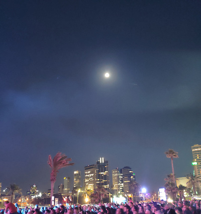 Urban park at night with a crowd dancing at a  concert