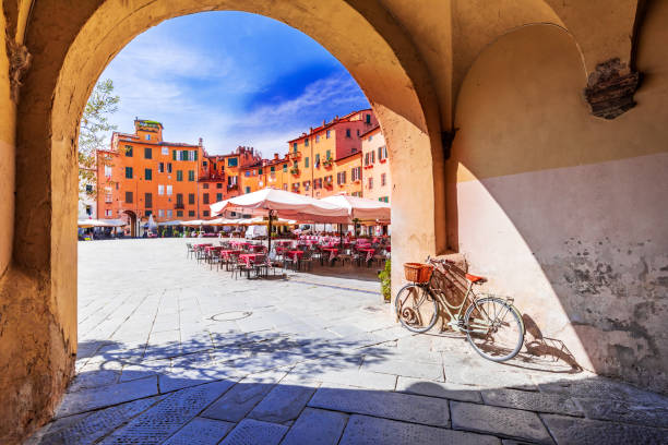 Lucca, Italy - Piazza dell'Anfiteatro, scenic sight of Tuscany Lucca, Italy - View of Piazza dell'Anfiteatro square through the arch, ancient Roman Empire amphitheater, famous Tuscany. lucca stock pictures, royalty-free photos & images