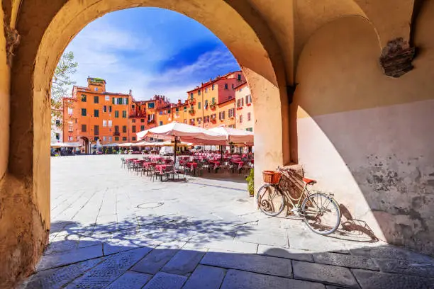 Lucca, Italy - View of Piazza dell'Anfiteatro square through the arch, ancient Roman Empire amphitheater, famous Tuscany.