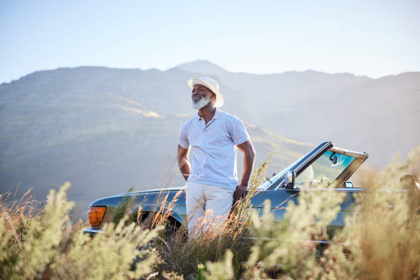 istock Smiling mature man looking at the view during a break from a scenic drive 1387322159