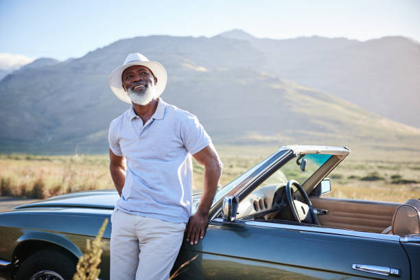 Smiling mature man enjoying the view during a break from a scenic drive stock photo