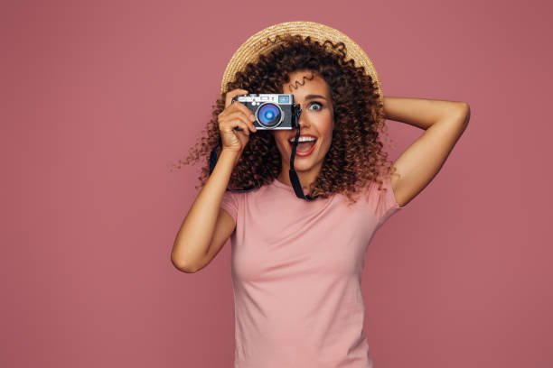 istock Happy beautiful woman holding analog camera 1387322513
