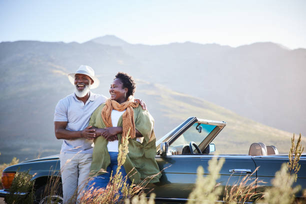 Laughing mature couple taking a break from a scenic road trip stock photo