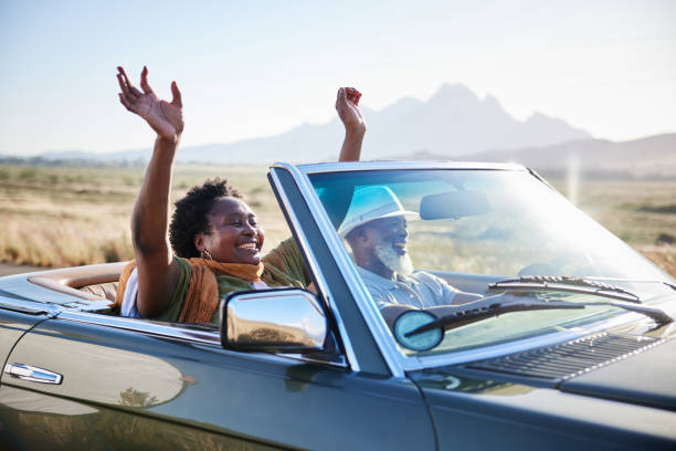 femme souriante s’amusant lors d’un road trip pittoresque avec son mari en été - road trip photos et images de collection