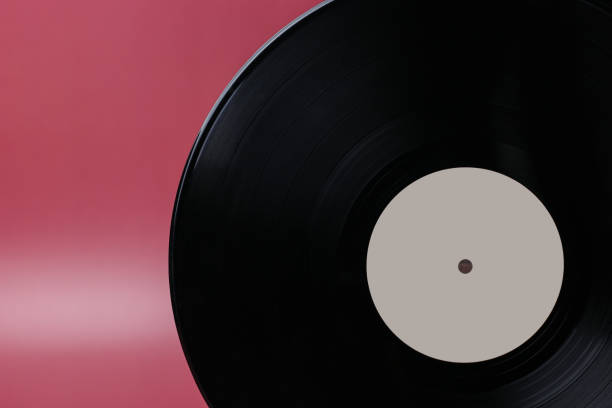 istock Classic vinyl record close-up on a red burgundy background, outdated data storage, music 1387324943