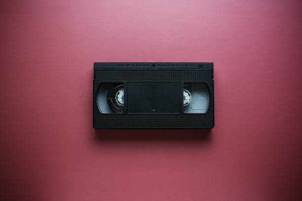 istock Close-up classic cassette tape on a red-burgundy background, outdated data storage 1387325104