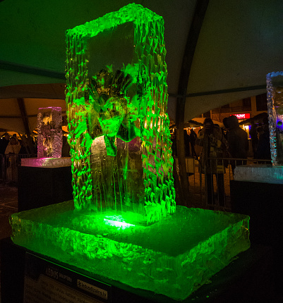 Jelgava / Latvia - February 10th, 2017: Mask frozen into ice sculpture at night of International Ice Sculpture Festival in Jelgava - green light