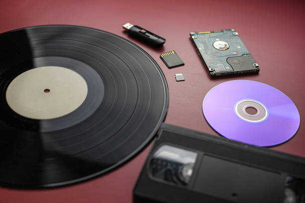 istock The evolution of recording and storing music and data, vinyl record, cassette, disk, hard drive, flash cards on a red-burgundy background, close-up, top view 1387325162