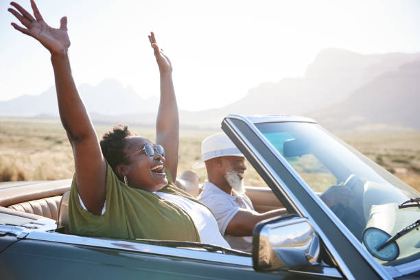 Woman laughing during a scenic road trip with her husband in the summertime stock photo