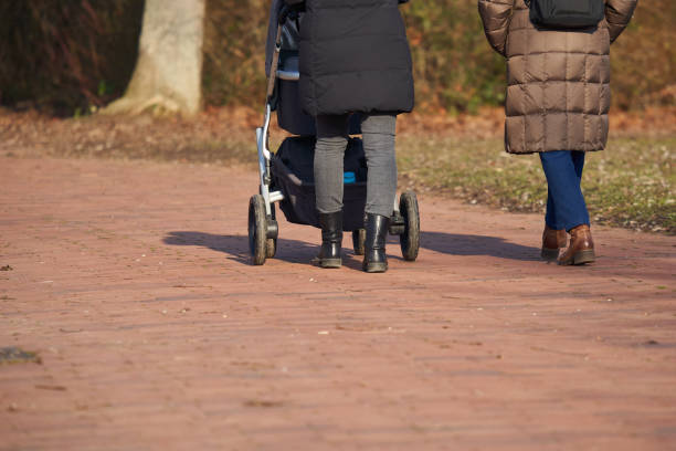 istock 2 women with strollers. People with warm clothes. Rear view. 1387325351