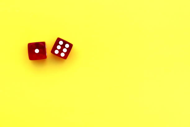 istock Red dice with white markings on a yellow background with space for text. 1387325484