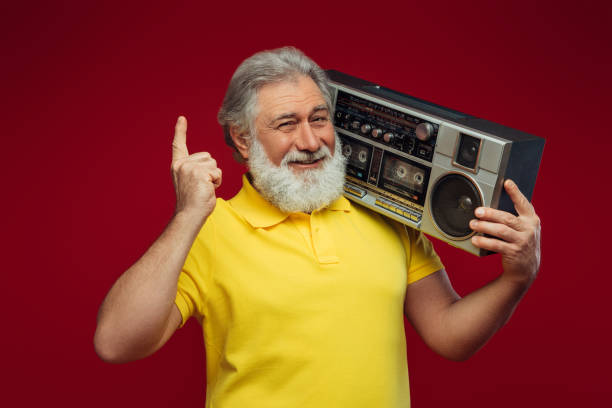istock Old man holding with cassette boom box enjoying music 1387326369