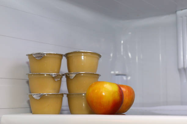 Individual  containers of applesauce inside of a fridge stock photo