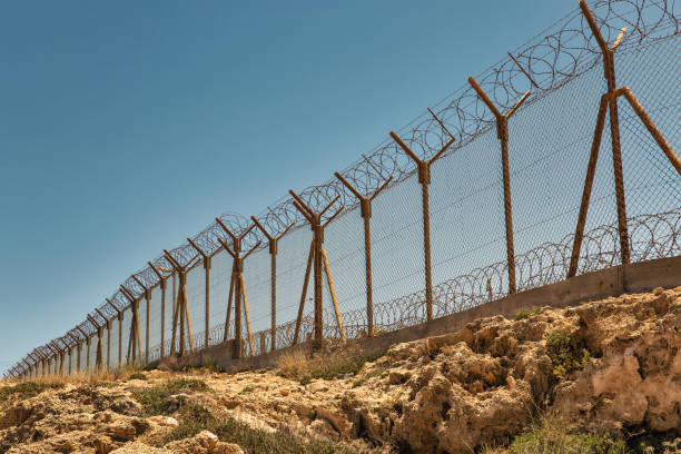 istock Military base with barbed wire fence. 1387330416