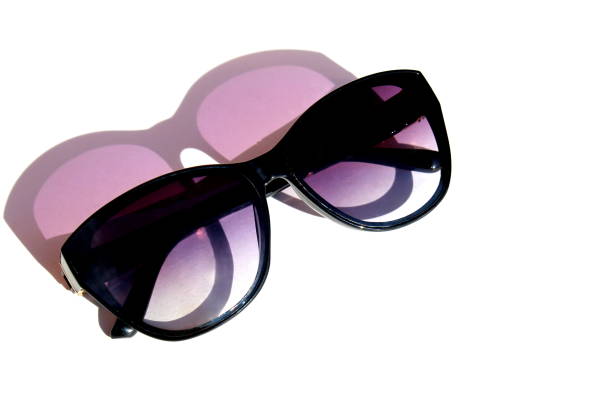 Purple sunglasses lie on a white background.