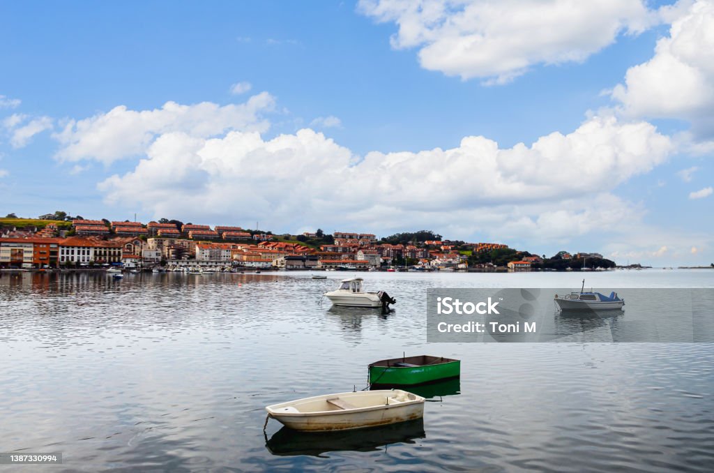 Puerto de San Vicente de la Barquera, with its boats on a day of blue sky and white clouds Views of the bridge of the fishing village of San Vicente de la Barquera with the boats in the port. Cantabria, Spain Cantabria Stock Photo