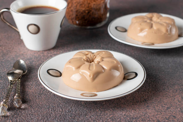Coffee dessert made from cream and gelatin in portion molds on a brown background. Dessert Blancmange stock photo