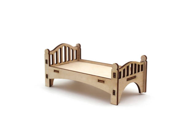 istock A toy miniature wooden bed stands on a white background. 1387332707