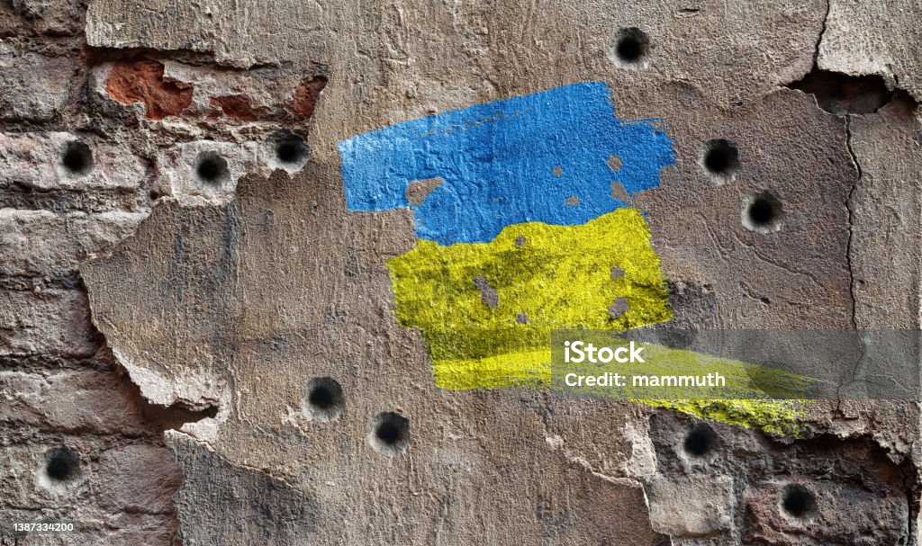 Ukrainian colors on damaged wall damaged wall Russian Invasion of Ukraine 2022 - 2023 Stock Photo