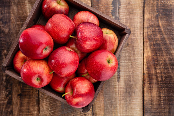 istock Ripe red apples in wooden box. Top view with space for your text. 1387335754
