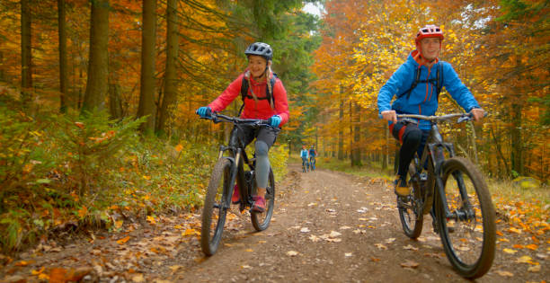 istock Young friends mountain biking in autumn forest 1387338285