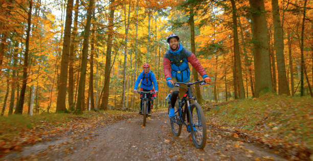 istock Young men mountain biking in autumn forest 1387338295