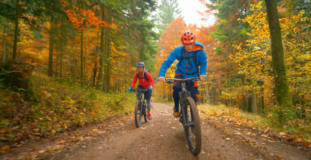 istock Young friends mountain biking in autumn forest 1387338302