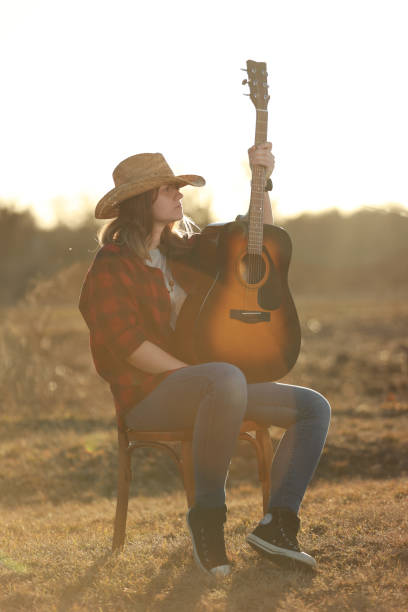 istock cowgirl with guitar at sunset 1387339418