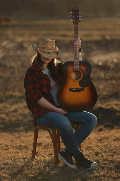 istock cowgirl with guitar at sunset 1387339436