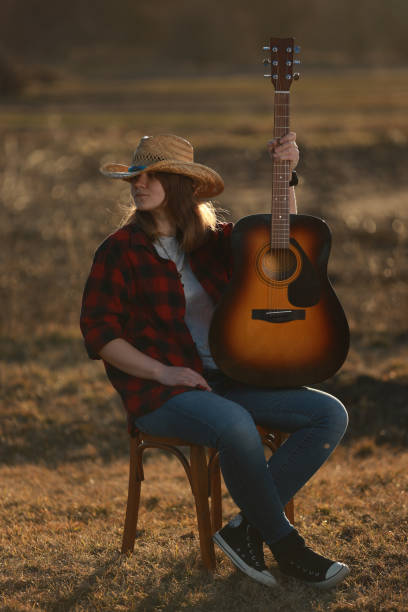 istock cowgirl with guitar at sunset 1387339473