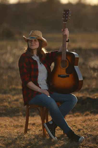 istock cowgirl with guitar at sunset 1387339477