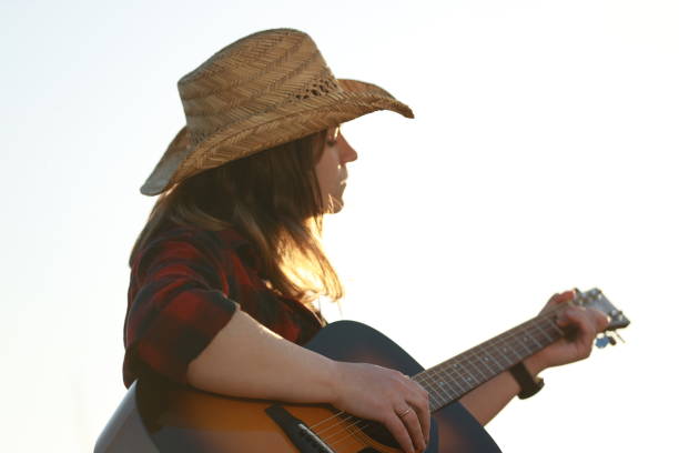 istock cowgirl with guitar at sunset 1387339576