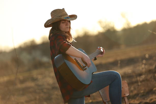 istock cowgirl with guitar at sunset 1387339588