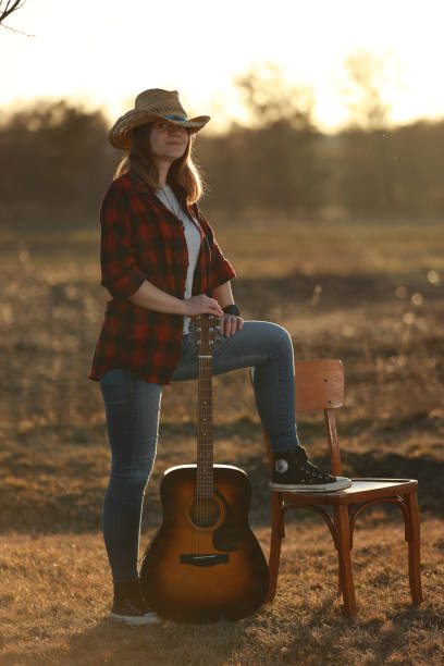 istock cowgirl with guitar at sunset 1387339622