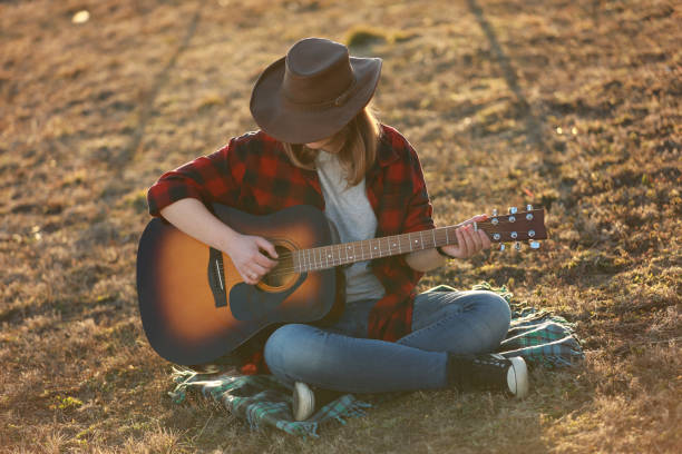 istock cowgirl with guitar at sunset 1387339682