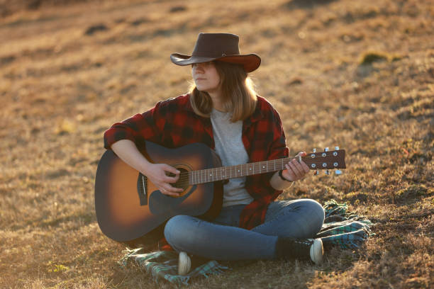istock cowgirl with guitar at sunset 1387339694
