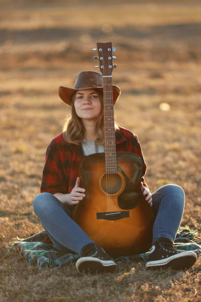 istock cowgirl with guitar at sunset 1387339839