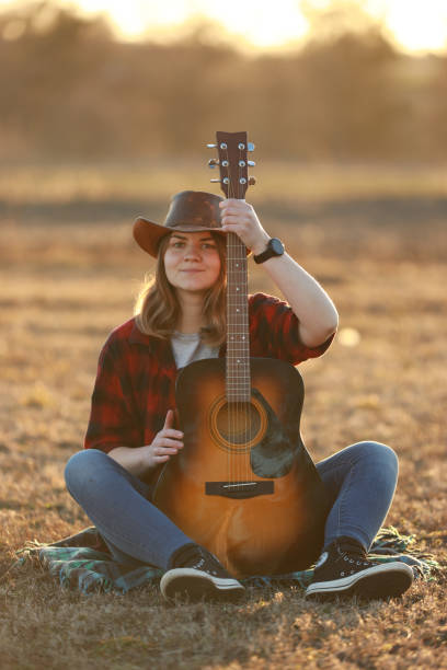 istock cowgirl with guitar at sunset 1387339843