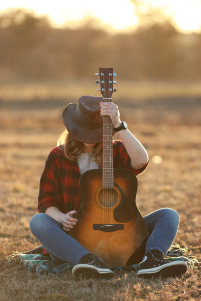 istock cowgirl with guitar at sunset 1387339850