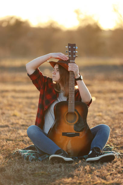 istock cowgirl with guitar at sunset 1387339869