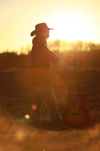 istock cowgirl with guitar at sunset 1387339913