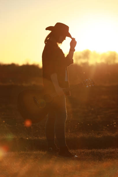 istock cowgirl with guitar at sunset 1387339916