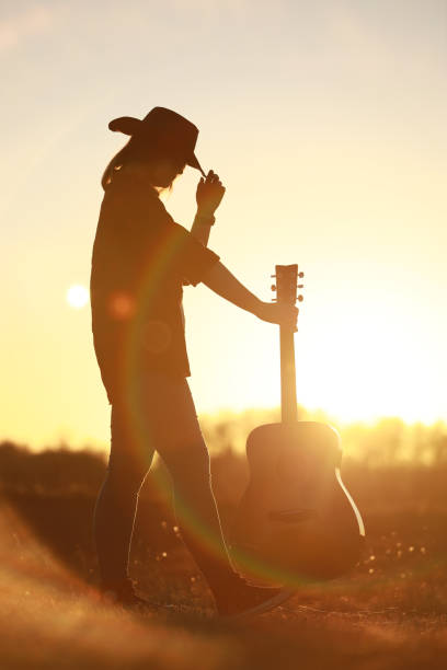 istock cowgirl with guitar at sunset 1387339927