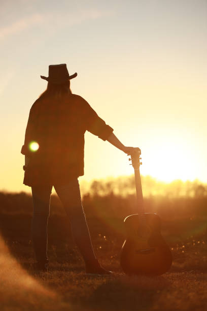 istock cowgirl with guitar at sunset 1387339936