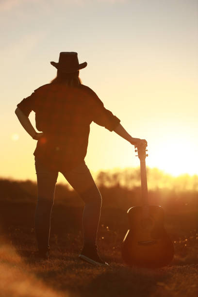 istock cowgirl with guitar at sunset 1387339938