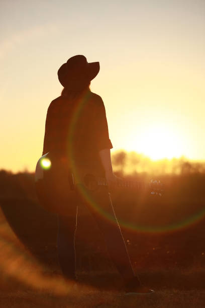istock cowgirl with guitar at sunset 1387339959